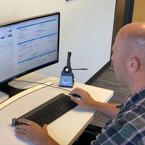 Man at a computer using Logis Solutions billing software